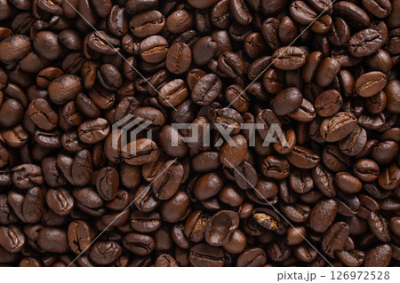Roasted coffee beans background. Top view of dark brown coffee beans. Close up image. 126972528