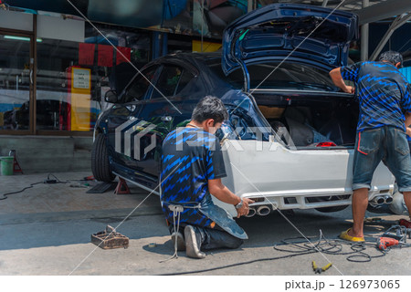 Checking car body work fiber bumper at car garage Checking car body work fiber bumper at car garage 126973065