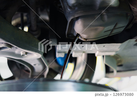 Car mechanic drain the old lubricant engine oil Car mechanic drain the old lubricant engine oil 126973080