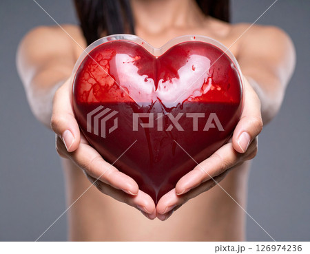 AI generated heart-shaped blood bag donating to the earth, half vibrant and fertile, half dark and barren. Symbolizes life, hope, and global impact of blood donation. 126974236