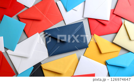 A scattered pile of colorful envelopes in red, blue, yellow, and white on a grey surface. A scattered pile of colorful envelopes in red, blue, yellow, and white on a grey surface. 126974647