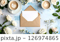 Coffee cups, envelope, blank card, and white flowers on a textured blue background, top view. 126974865