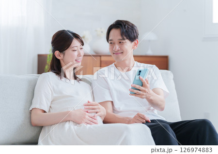 スマホを見る妊婦の妻と夫 126974883