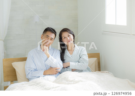 寝室で会話するミドル夫婦 126974956