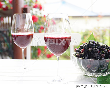 Mulberries in glass bowl with glasses of mulberry juice. 126974978