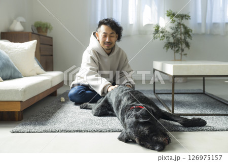 愛犬とリビングでくつろぐ男性　 126975157