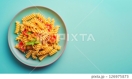 Bell pepper red and yellow spiral pasta spicy lunch on blue plate 126975873