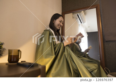 よもぎ蒸しながら読書をする女性イメージ 126976397