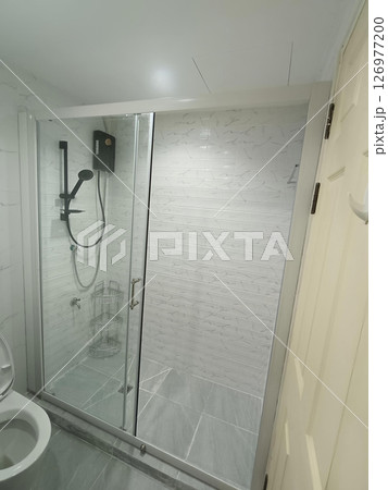 A clean shower stall, reflecting sense of modern minimalist tranquility, boasts its smooth glass, beckoning one to step into relaxing, invigorating experience A clean shower stall, reflecting sense of modern minimalist tranquility, boasts its smooth glass, beckoning one to step into relaxing, invigorating experience 126977200