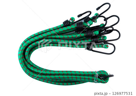 Set of green bungee cords with black metal hooks, coiled together and secured for transport. Elastic tie down straps on white background. 126977531