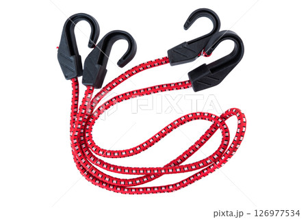 Red bungee cord with four black plastic hooks on a white background. Durable elastic strap for securing items in transport, storage, or outdoor use. 126977534