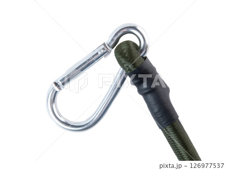 Close-up of a metal carabiner attached to a green elastic bungee cord on a white background. Durable tie down strap for automotive and outdoor use. 126977537