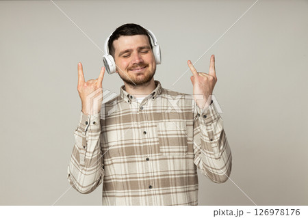 Attractive young guy listening to music in headphones Attractive young guy listening to music in headphones 126978176