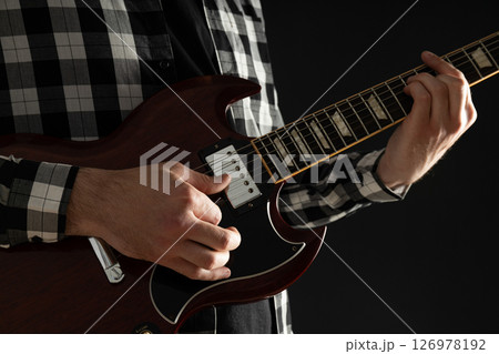 A man plays a beautiful guitar close-up 126978192