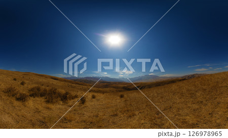 Dry, open landscape with rolling hills under a bright sun. Dry, open landscape with rolling hills under a bright sun. 126978965
