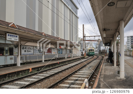 March 28 2025 Train Station with Rail Tracks and Waiting Commuters 126980976