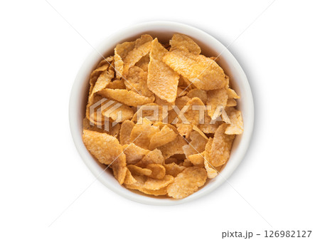 Top view bowl with original yellow corn flakes breakfast cereal on white.Macro. Top view bowl with original yellow corn flakes breakfast cereal on white.Macro. 126982127