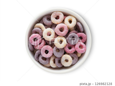 Top view bowl with various fruits circles and vitamins breakfast cereal on white.Macro. 126982128