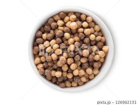 Top view bowl with healthy mini peanut butter puffs breakfast cereal on white.Macro. Top view bowl with healthy mini peanut butter puffs breakfast cereal on white.Macro. 126982131