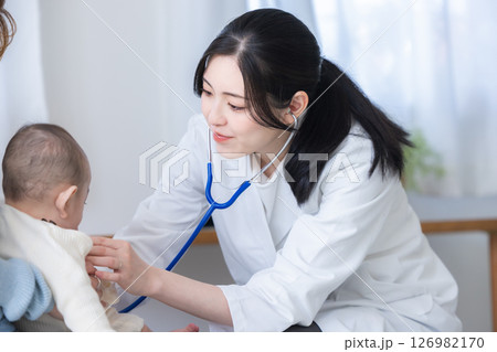 赤ちゃんを診察する女性医師 126982170