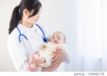 赤ちゃんを抱いた若い女性医師 126982176