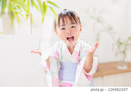 七夕　笹の葉に短冊を飾り付ける2歳の女の子　願い事　笹飾り　願いごと　一夜飾り 126982207