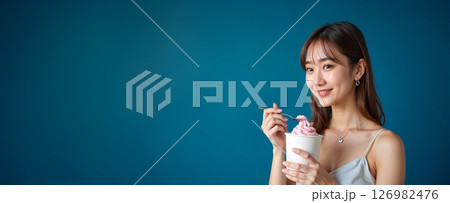 ピンクのソフトクリームを楽しむ夏の女性 126982476
