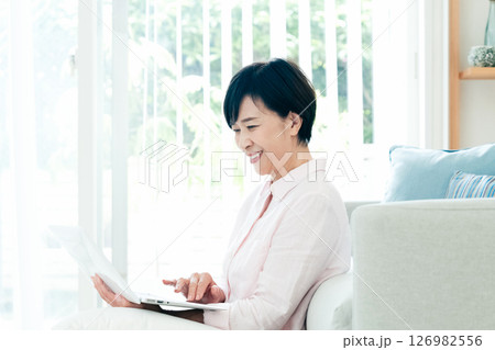 リビングでパソコンを操作する中高年女性 126982556