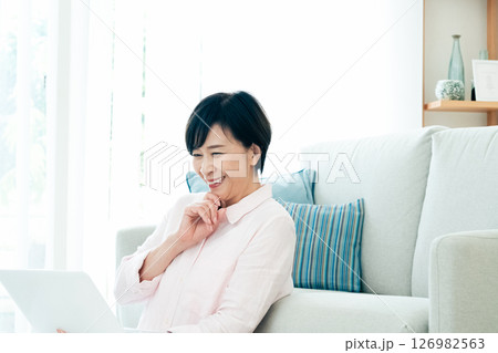 リビングでパソコンを操作する中高年女性 126982563