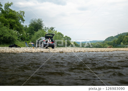 Camping near Mountain River Woman in Car Trunk 126983090