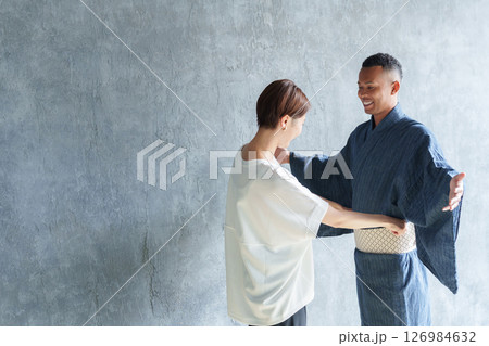 外国人観光客に浴衣を着付けるスタッフ 126984632