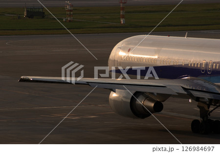 夕日を浴びて滑走路に向かう飛行機 夕日を浴びて滑走路に向かう飛行機 126984697