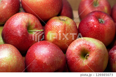 Bright red apples, with few wet drops, displayed on food market, closeup detail Bright red apples, with few wet drops, displayed on food market, closeup detail 126985073