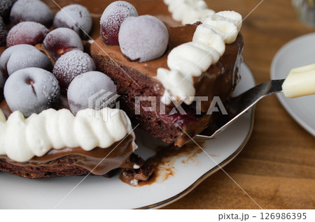 手作りのブルーベリーガナッシュケーキの一切れをすくいあげている 126986395