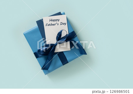 Blue gift box and blank on pastel blue background. View from above. Copy space. Happy Fathers Day - text. 126986501