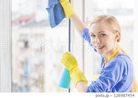 Woman cleaning window at home 126987454
