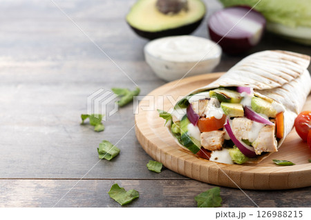 A delicious grilled chicken wrap with vegetables and avocado 126988215