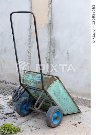 A construction cart leaning against the wall of a building A construction cart leaning against the wall of a building 126988563