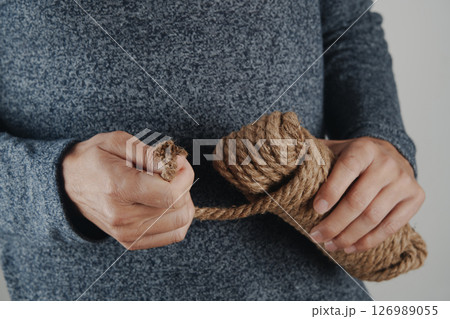 man pulling rope from a tangled coil man pulling rope from a tangled coil 126989055