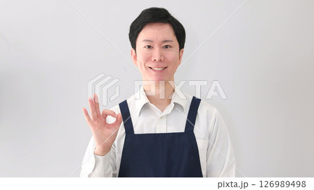 OKサインの笑顔のエプロン姿のアジア男性 126989498
