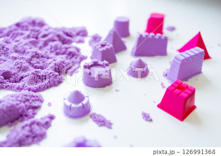 Purple kinetic sand with castle molds on white surface Purple kinetic sand with castle molds on white surface 126991368
