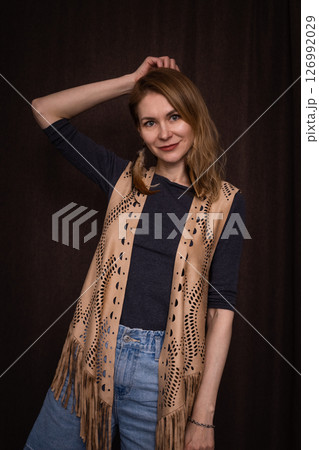A young girl poses in a boho style suede vest. 126992029