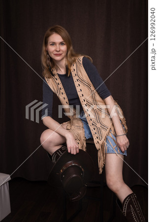 A young girl poses in a boho style suede vest. 126992040