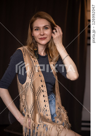 A young girl poses in a boho style suede vest. 126992047