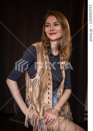 A young girl poses in a boho style suede vest. 126992051