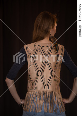 A young girl poses in a boho style suede vest. 126992055