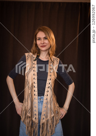 A young girl poses in a boho style suede vest. 126992067
