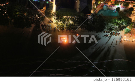 Tourists enjoying fire show on beach at night in tropical resort Tourists enjoying fire show on beach at night in tropical resort 126993163