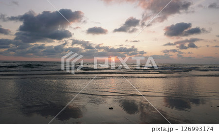 Gentle waves washing ashore during a beautiful sunset at the beach Gentle waves washing ashore during a beautiful sunset at the beach 126993174