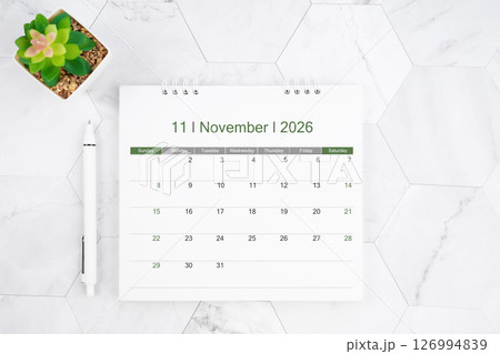 Desk calendar on month of November 2026 with pen on white marble background. 126994839